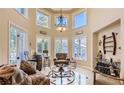 Bright living room with high ceilings, a decorative chandelier and large picture windows at 7201 Mission Hills Dr, Las Vegas, NV 89113