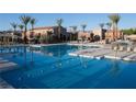 A large, inviting pool is surrounded by lounge chairs and palm trees on a sunny day at 776 Tillis Pl, Las Vegas, NV 89138