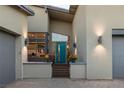 Home exterior showing the front entry with a bright turquoise door, modern lighting, and manicured landscaping at 10271 Meridian Hill Ave, Las Vegas, NV 89135