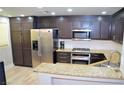 Modern kitchen with stainless steel appliances, granite countertops, and wood flooring at 11830 Portina Dr # 2030, Las Vegas, NV 89138