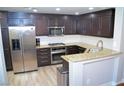 Modern kitchen with stainless steel appliances, granite countertops, and wood flooring at 11830 Portina Dr # 2030, Las Vegas, NV 89138