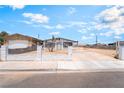 Single-story home featuring a white fence, long driveway, and minimal landscaping at 1328 Balzar Ave, Las Vegas, NV 89106