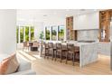 Open gourmet kitchen boasts a marble island with bar seating, stainless appliances, and stylish pendant lighting at 1987 Orchard Mist St, Las Vegas, NV 89135