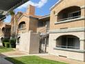 Exterior view showcases a building with stucco walls, red tile roof, and charming arched balconies on each level at 220 Mission Catalina Ln # 203, Las Vegas, NV 89107
