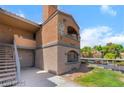 A street-level exterior showing stairs leading to a unit on the upper level with lovely landscaping around the building at 221 Mission Catalina Ln # 104, Las Vegas, NV 89107