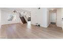 Spacious living room features light wood flooring, neutral walls, and view of staircase and the entrance hallway at 2745 Poppyseed Way, Las Vegas, NV 89142