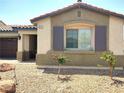 Close up of the front of a charming single-story home with desert landscaping and decorative shutters at 2822 Chetco River St, Laughlin, NV 89029