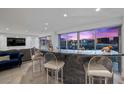 Open living area with a bar area including granite countertop and panoramic views of the city at 3111 Bel Air Dr # 21A & 21C, Las Vegas, NV 89109
