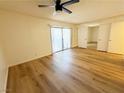 Bright bedroom featuring vinyl wood flooring, sliding glass door, and mirrored closet at 3270 Liahona Way, Las Vegas, NV 89121