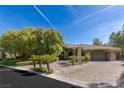 Paver driveway and manicured front yard featuring palm trees that enhance the curb appeal of this elegant home at 33 Promontory Ridge Dr, Las Vegas, NV 89135