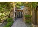 Charming walkway to the main entrance, showcasing beautiful stonework and lush landscaping for a welcoming feel at 33 Promontory Ridge Dr, Las Vegas, NV 89135
