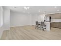 Open-concept living space featuring the kitchen with a stainless fridge and breakfast bar at 3621 Arcadian Sea St, Las Vegas, NV 89106
