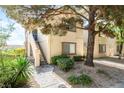 Inviting condo exterior with shade trees, lush landscaping, and a private entrance stairway at 3673 Ian Thomas St # 201, Las Vegas, NV 89129