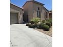 Attractive stucco home with desert landscaping, driveway, and decorative wrought iron gate at 4408 Oasis Plains Ave, North Las Vegas, NV 89085