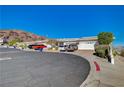View of multiple townhomes, each with a two-car garage and desert landscaping at 483 Marina Cv, Boulder City, NV 89005