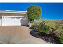 Front yard featuring a manicured lawn, desert plants, and a two-car garage at 483 Marina Cv, Boulder City, NV 89005