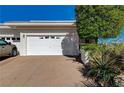 A well maintained garage area with a manicured lawn with desert foliage at 483 Marina Cv, Boulder City, NV 89005