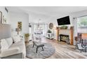 Bright living room featuring hardwood floors, a fireplace, and lots of natural light at 6536 Pleasant Plains Way, Las Vegas, NV 89108