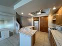 Bright kitchen with white appliances, tiled countertops and floors, plus wooden cabinets at 8704 Autumn Wreath Ave, Las Vegas, NV 89129