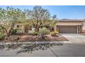 Single-story home featuring desert landscaping, a covered entryway, and attached two-car garage at 9421 Wisdom Valley Ave, Las Vegas, NV 89149