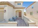 Inviting front porch with seating area, brick pavers, and an arched entryway to the home at 953 Via Del Tramonto St, Henderson, NV 89011