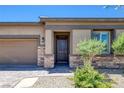 Close-up of the home's entrance, featuring a stylish door and stone accents at 10181 Mount Harlow Ct, Las Vegas, NV 89141