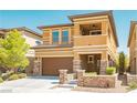 Charming two-story home with a brown garage door, accented with stone pillars and a well-kept lawn at 10404 Mystic Pine Rd, Las Vegas, NV 89135
