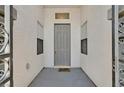 The home has a gray front door with sidelights and a decorative welcome mat at 10701 Morning Harbor Ave, Las Vegas, NV 89129