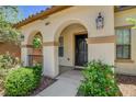 Inviting front entrance with arched porch, mature shrubs, and stylish outdoor lighting at 10804 Mason Hill Ave, Las Vegas, NV 89166