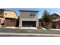 Exterior view of a two-car garage with a black door and a low-maintenance yard at 10804 Mason Hill Ave, Las Vegas, NV 89166