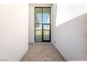 Modern entryway showcasing a tall glass door and sleek tiled flooring at 10919 Vista Altura Ave, Las Vegas, NV 89135