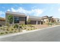 Contemporary home with a manicured yard, showcasing a brick driveway and desert landscaping at 10919 Vista Altura Ave, Las Vegas, NV 89135