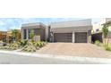 A modern home featuring a brown garage door with horizontal windows and a brick driveway at 10919 Vista Altura Ave, Las Vegas, NV 89135