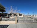 Inviting single-story home with a secure wrought iron gate and classic desert landscaping at 1152 Miller Ave, Las Vegas, NV 89106