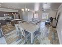 Open-concept living space with wood-look flooring, dining area, and modern kitchen at 210 Magnolia Blvd, Pahrump, NV 89048