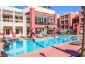Beautiful community pool with ample seating for residents and a modern clubhouse visible behind at 23 E Agate Ave # 308, Las Vegas, NV 89123