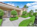 Inviting covered front entrance surrounded by verdant, manicured greenery and a glass panel front door at 2825 Brianwood Ct, Las Vegas, NV 89134