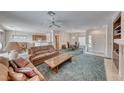Spacious living room features a ceiling fan, fireplace, and open access to the kitchen and dining area at 3050 Canal Walk Rd, Henderson, NV 89052
