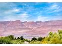 Scenic view of mountain range under a clear blue sky with the tops of trees in the foreground at 3050 Canal Walk Rd, Henderson, NV 89052