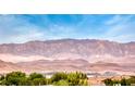 Wide scenic view of a mountain range under a blue sky, with tiled roofs and trees in the foreground at 3050 Canal Walk Rd, Henderson, NV 89052