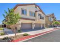 Two-story home featuring neutral paint, attached garages, small balcony, and a tile roof at 4725 Blaise Ave # 103, North Las Vegas, NV 89084