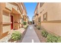 Charming walkway lined with lush landscaping between two residential buildings at 4725 Blaise Ave # 103, North Las Vegas, NV 89084