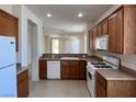 Functional kitchen with light countertops, white appliances, and wood cabinets at 5147 Progresso St, Las Vegas, NV 89135