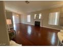 Open-concept living room featuring a fireplace, hardwood floors, and bright natural light at 5824 Red Gull St, Las Vegas, NV 89149
