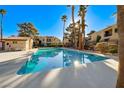 Refreshing community pool surrounded by lush landscaping and palm trees on a sunny day at 601 Cabrillo Cir # 536, Henderson, NV 89015