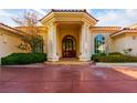 Grand entrance with stately columns and a covered porch welcomes you to this exquisite residence at 8120 W Red Coach Ave, Las Vegas, NV 89129