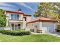Charming two-story home with a red tile roof, manicured lawn, and white fence and gate at 8224 Horseshoe Bend Ln, Las Vegas, NV 89113