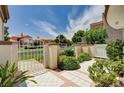 Landscaped front yard with tiled walkway and white fence and gate leading to the home at 8224 Horseshoe Bend Ln, Las Vegas, NV 89113