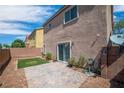 A cozy backyard with a paved patio area, a patch of artificial turf, and a block wall for privacy at 9031 Jumping Jacks Ave, Las Vegas, NV 89178