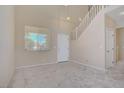 Neutral living room with large window and staircase leading to the second floor at 9451 Natoma Station Pl, Las Vegas, NV 89123